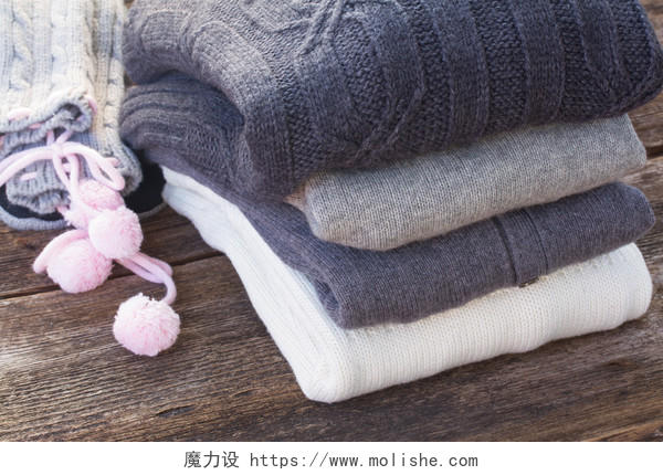 堆栈的折叠羊毛灰色和白色的衣服上木制背景
